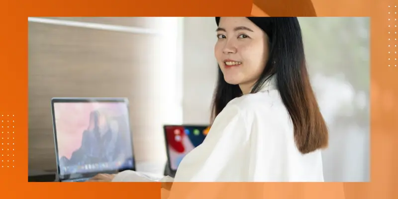 image of a smiling woman in front of a laptop