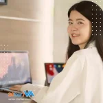 image of smiling woman with a laptop in front of her