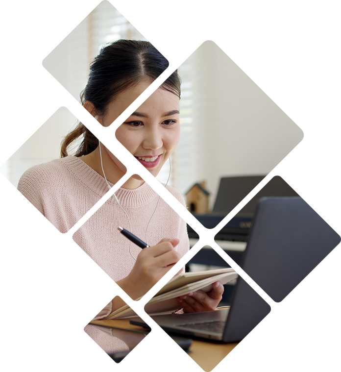 Person writing down notes in front of a laptop
