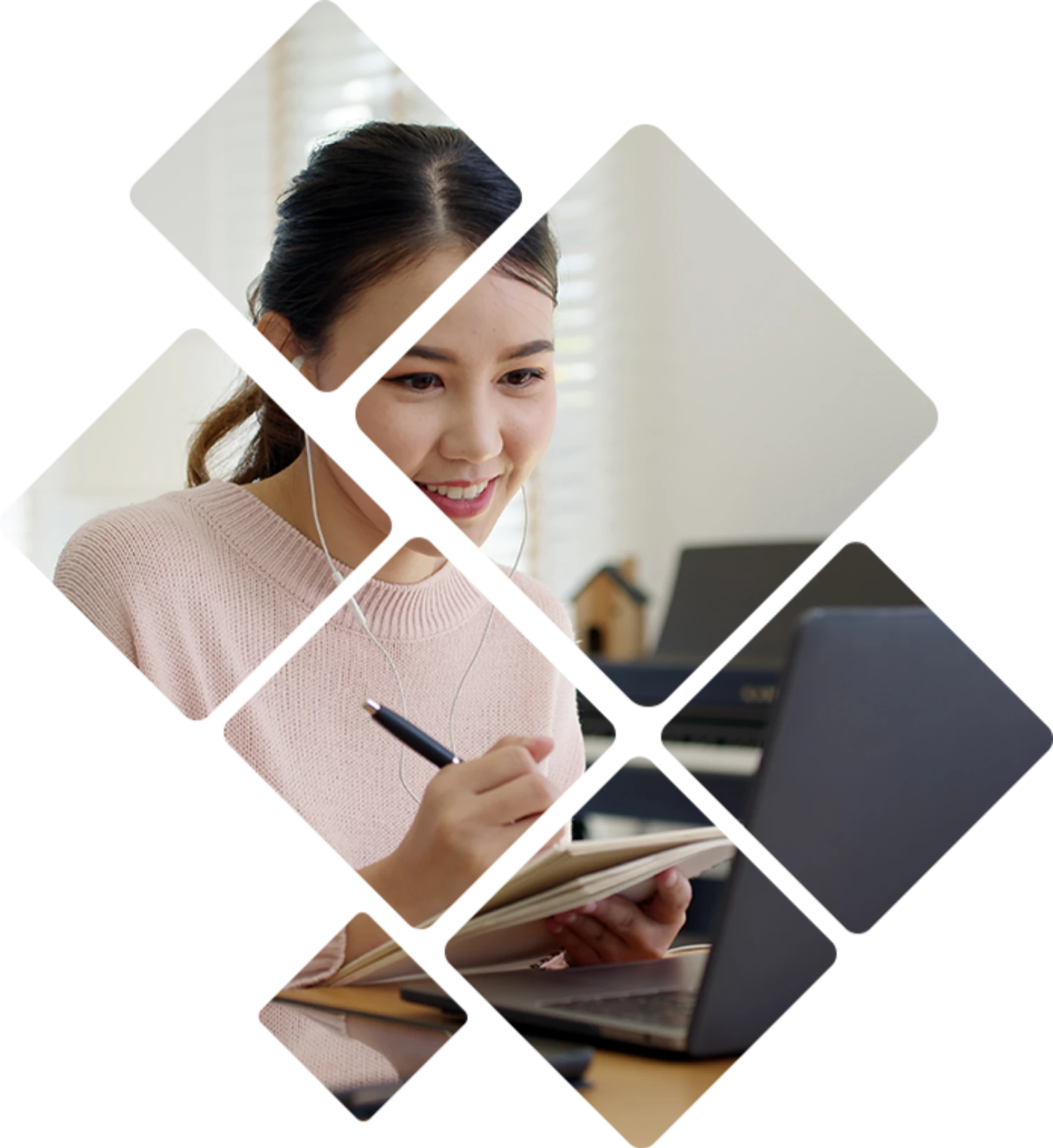 Person writing down notes in front of a laptop